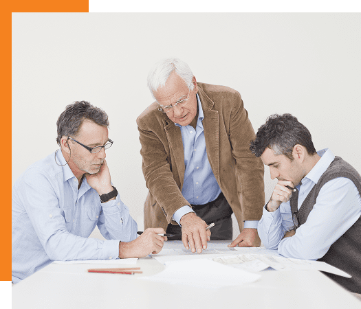 Three men in a meeting discussing documents.